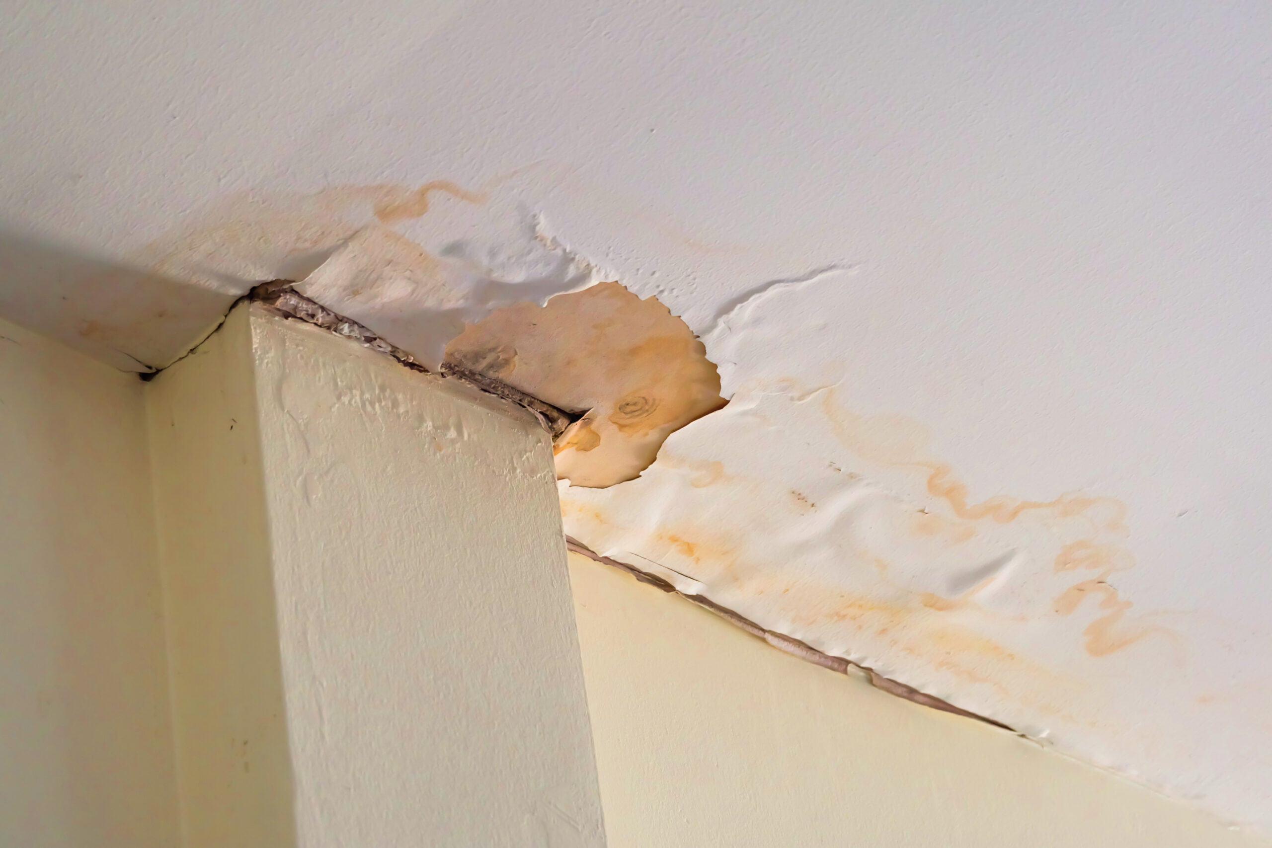 Water-stained ceiling with visible damage in a residential apartment